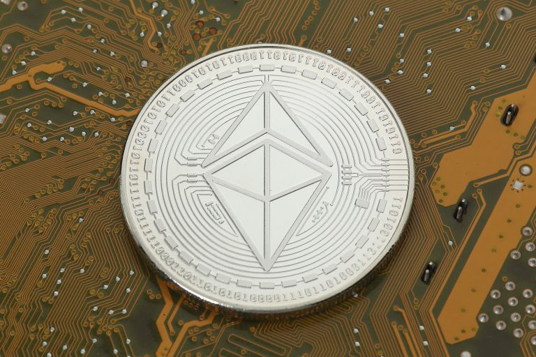 桌面上的实体以太坊纪念币，示意网络与资产层次。